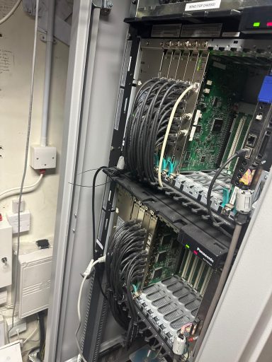 A server rack with multiple circuit boards and connected cables.