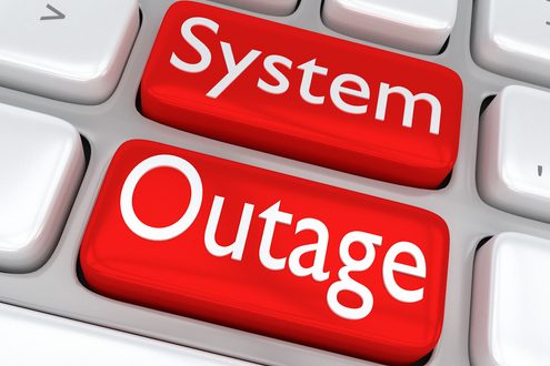 Red keys displaying the text "System Outage" on a computer keyboard.