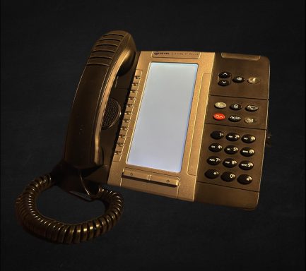 A black desk telephone with a handset and numeric keypad.