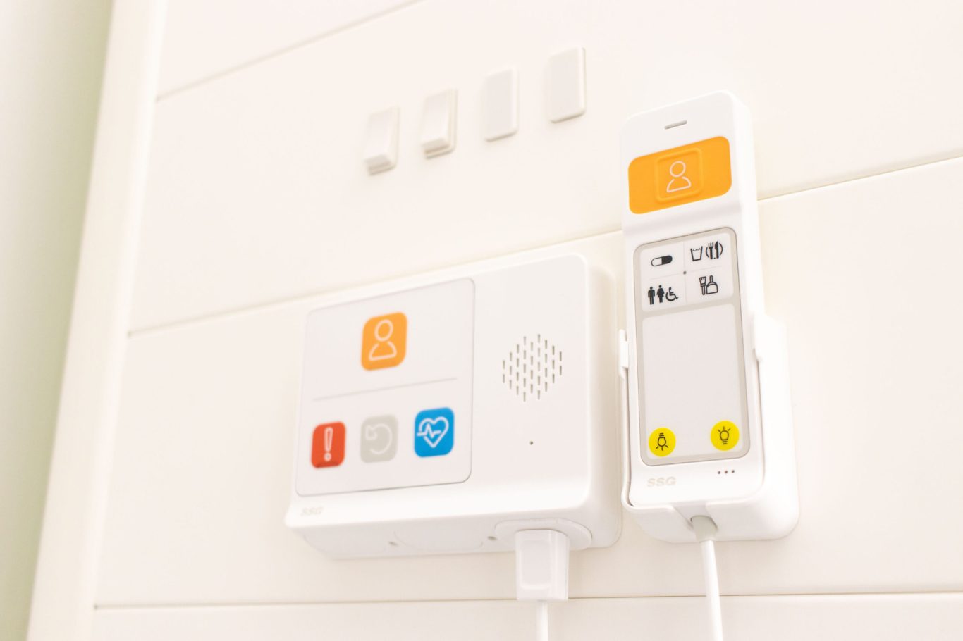 A wall-mounted intercom system with buttons and a speaker.