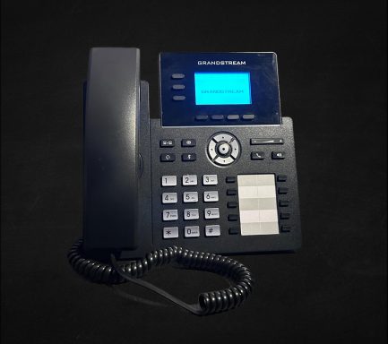Black desk telephone with a digital display and multiple buttons.
